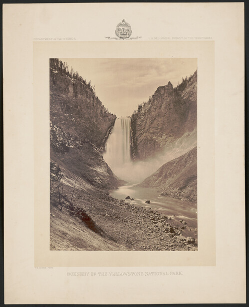 Mountain valley with dramatic waterfall cascading between steep rocky cliffs