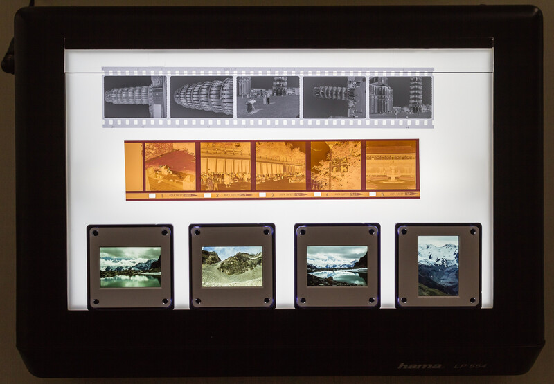 Framed display of film strips and photographic slides showing architectural and landscape imagery