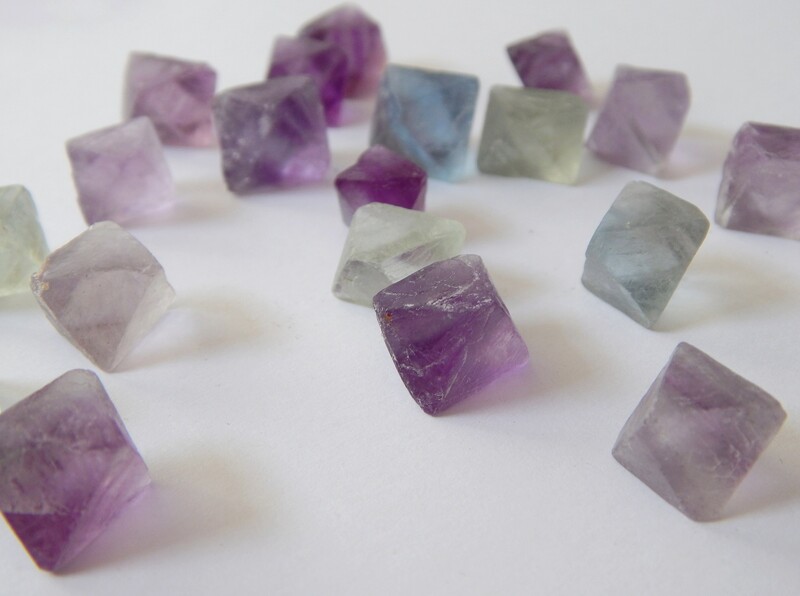 Natural fluorite cleaves into octahedra and takes its green and purple coloring from impurities, the same impurities that make mined crystals useless for a large camera lens element