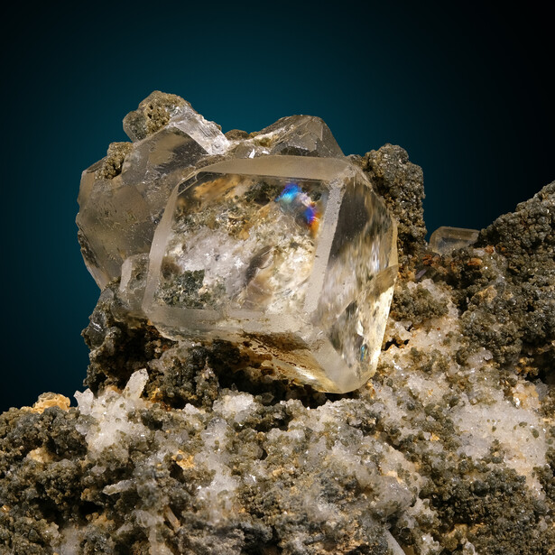 A water-clear crystal of optical fluorite from the Nikolaevsky mine at Dalnegorsk, Russia, roughly 8 mm on a side, with Newton's rings visible inside it