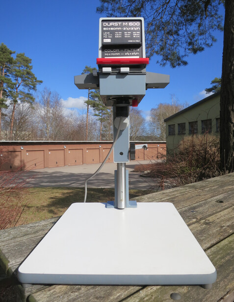 A Durst M600 vertical enlarger standing on its baseboard and column