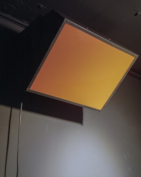 An amber darkroom safelight filter glowing overhead
