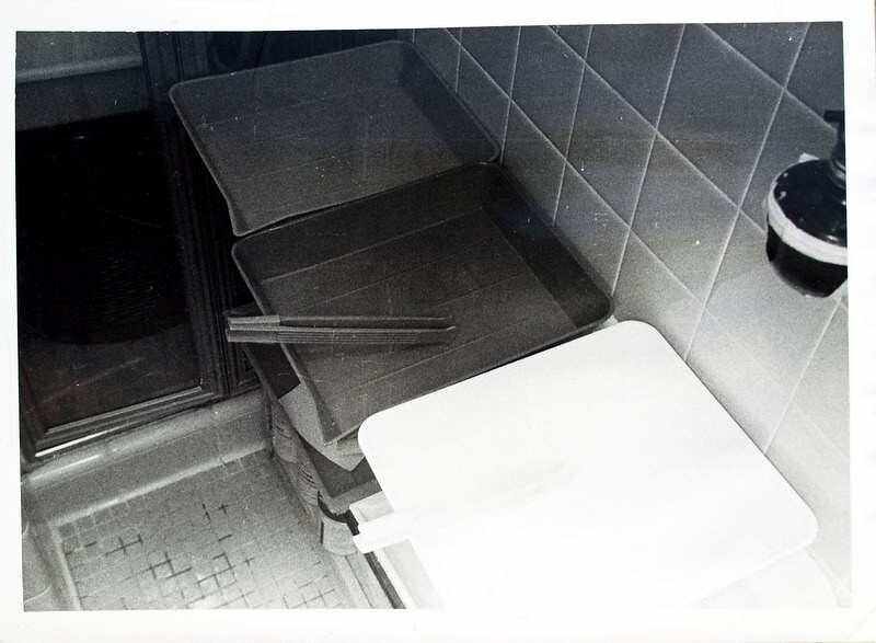 Darkroom processing trays with a pair of print tongs resting across them