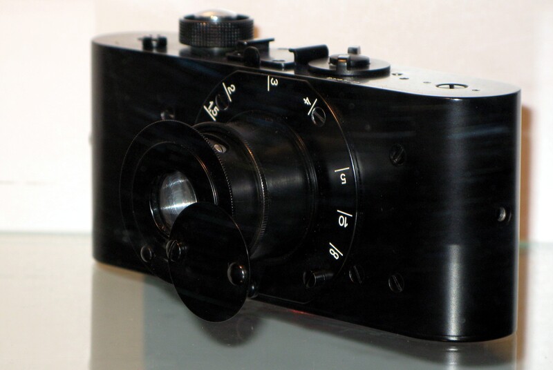 A replica of the Ur-Leica, Oskar Barnack's prototype, in the camera museum in Vevey, Switzerland, showing the plain body, the collapsing lens barrel and the pivoting lens cap