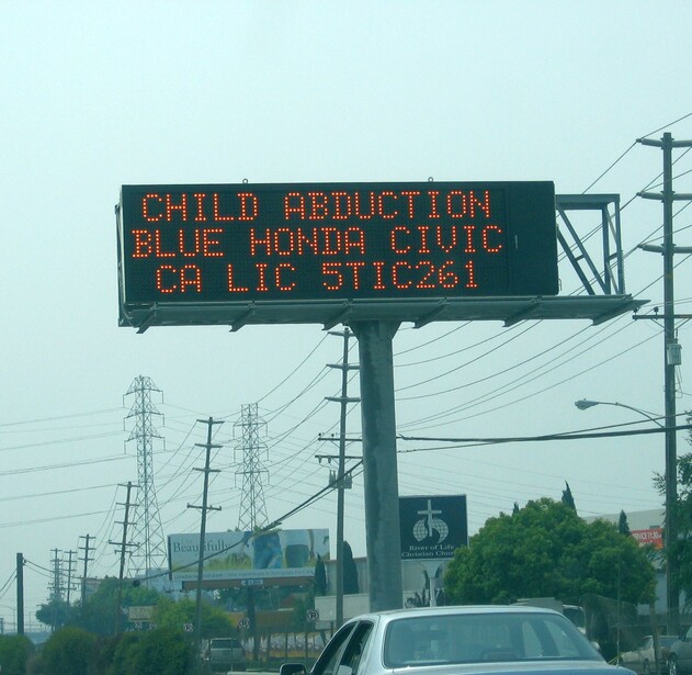A California highway message sign carries an AMBER Alert as text: the crime, the car, the plate, and no photograph