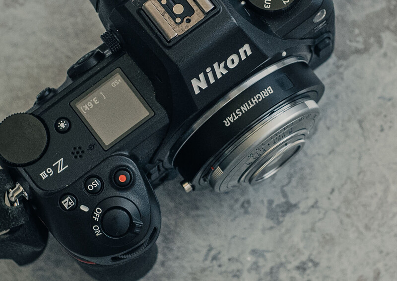 Nikon Z9 mirrorless camera with Nikkor lens mounted, shot from above on concrete surface