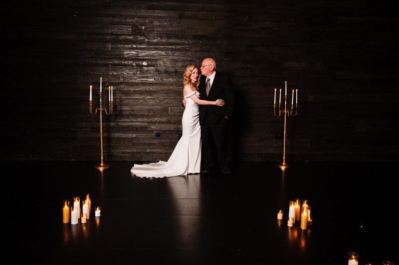 Bride and groom dancing at wedding reception with candelabra and candles