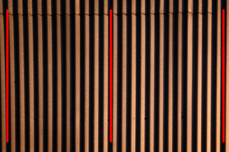 Abstract composition of vertical wooden slats with three red neon tubes