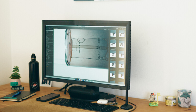 Desktop setup with monitor displaying design software and technical drawings
