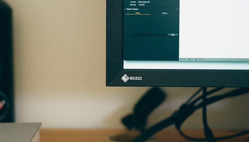 EIZO monitor displaying a dark-themed software interface on a desk workspace