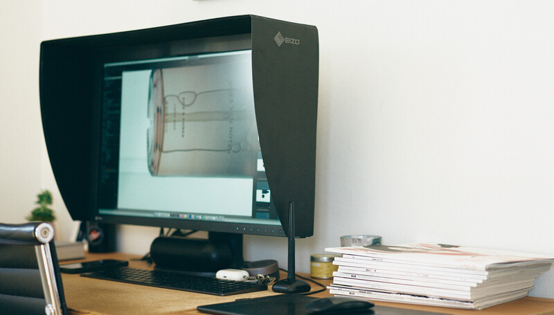 Monitor displaying architectural floor plan in studio setup with sun hood