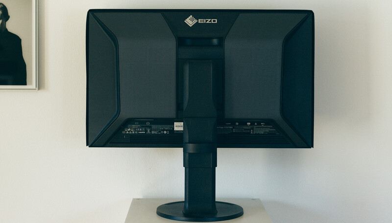 Rear view of EIZO monitor mounted on adjustable stand against white wall
