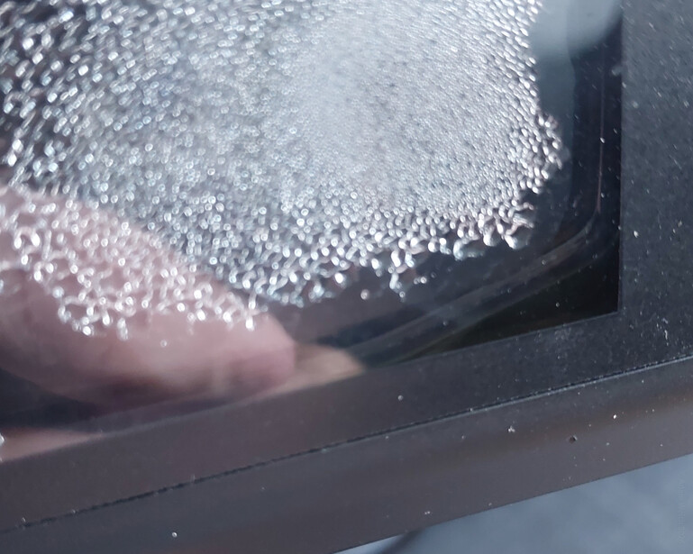 Close-up of water droplets splashing on a dark surface with shallow depth of field