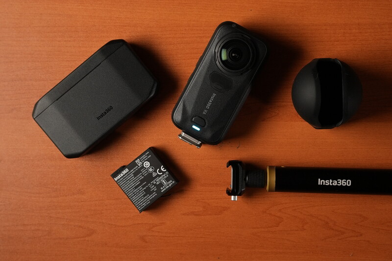 Insta360 camera accessories and components laid out on orange background