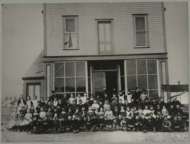The ritual predates the industry: a class posed outside their schoolhouse in 1889, nearly half a century before National School Studios opened for business