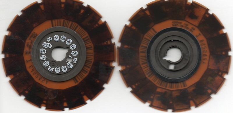 Two developed Kodak disc negatives on a light table, showing how tiny each of the 15 radial frames is and the numbered hub that indexed them