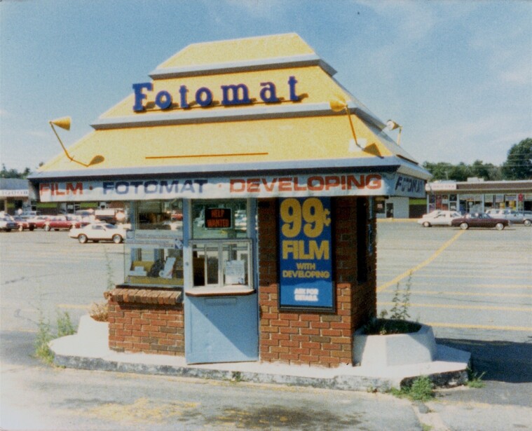 A Fotomat drive-up film booth photographed in 1987, the kind of shopping-center photofinishing outlet where disc and 35mm competed for the casual snapshot market
