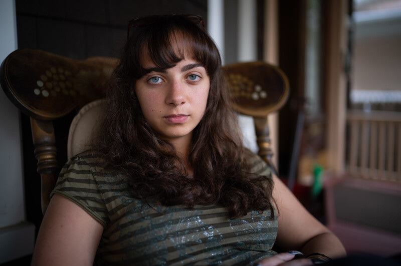 Girl sitting on a porch looking into the camera