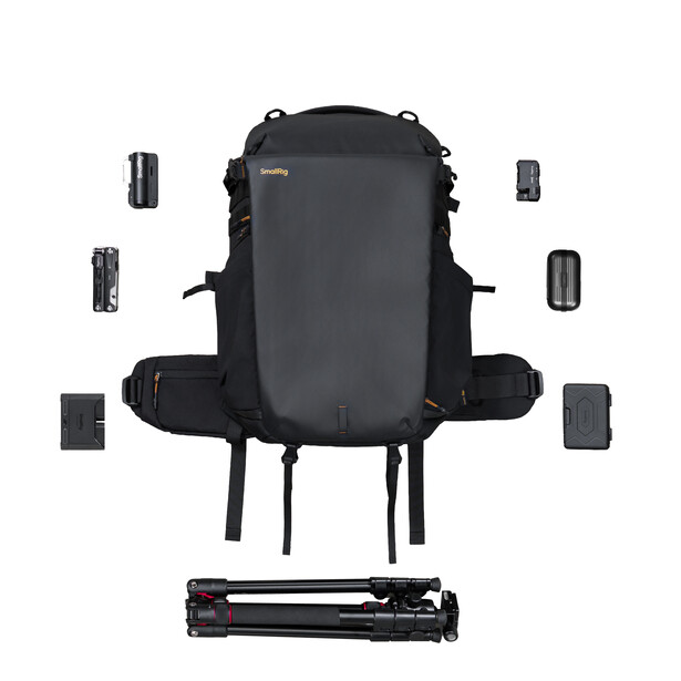 Camera backpack with modular accessory compartments and tripod laid out in flat lay arrangement