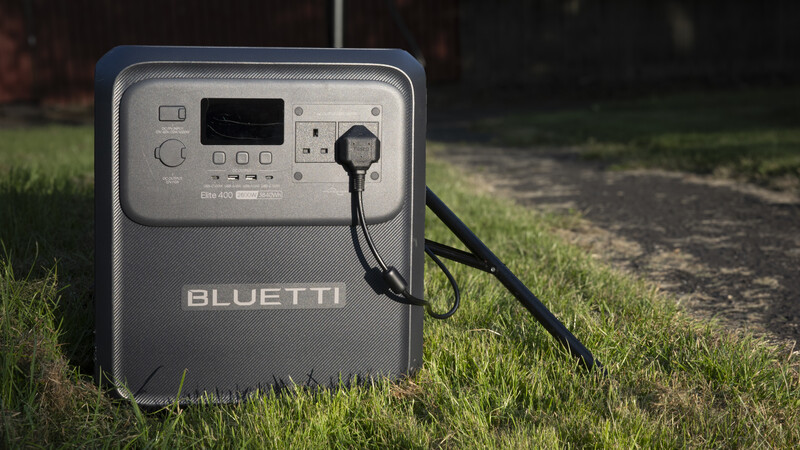 Bluetti portable power station with power cable on grass outdoors