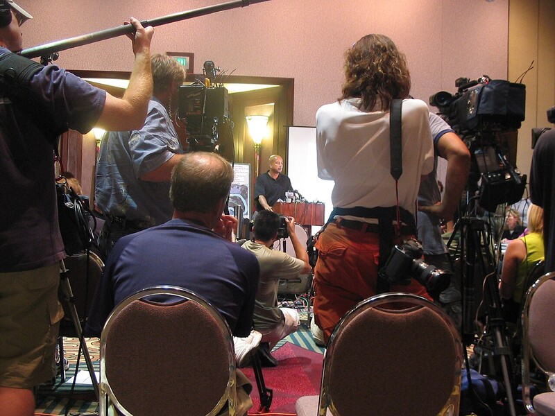 Video crews and a stills photographer work a New Orleans news conference on September 23, 2005