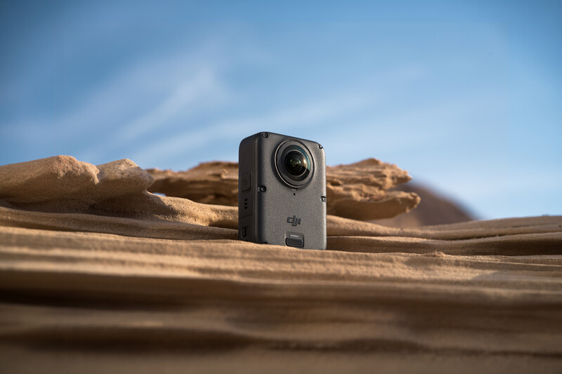DJI Osmo Action camera positioned on weathered wood with rocky desert landscape in background