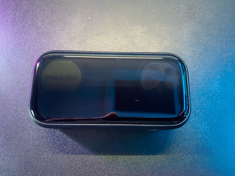 Smartphone with dark screen displayed on iridescent gradient surface