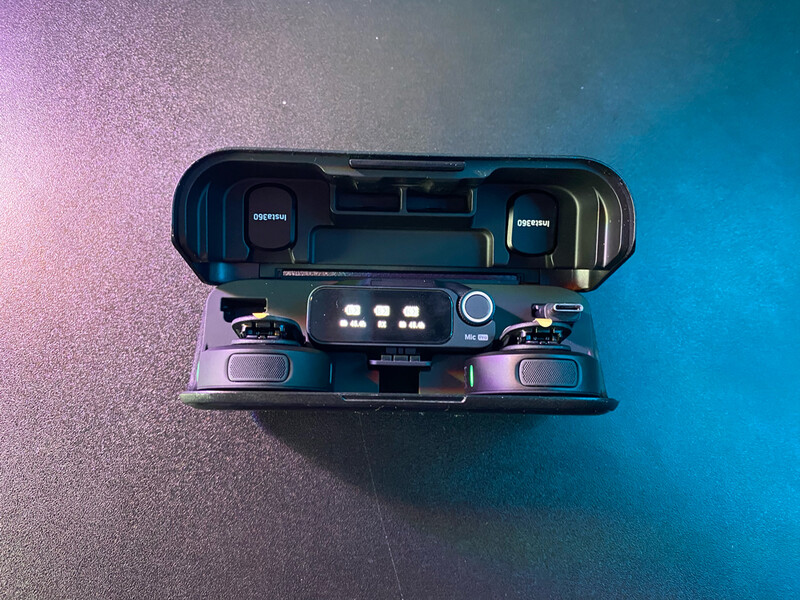 Top-down view of a vintage film camera with dual reels and control knobs against a gradient blue and pink background