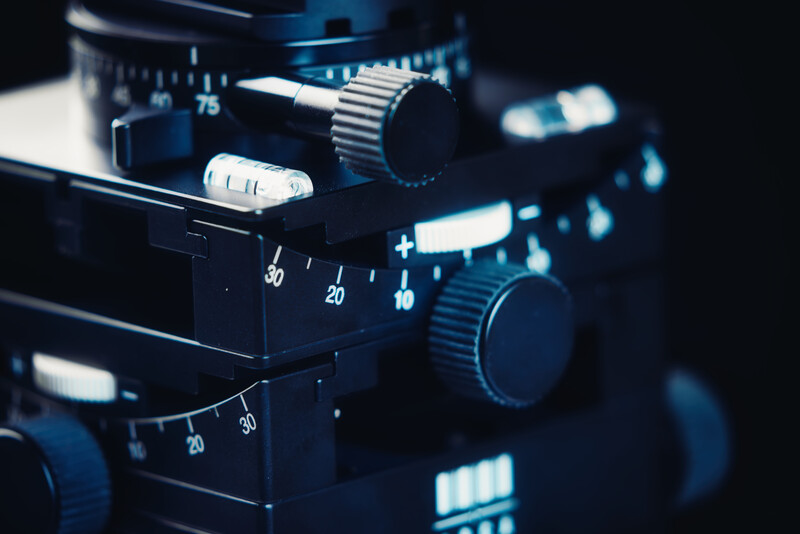 Close-up of film camera controls with numbered dials and knobs in blue-tinted lighting