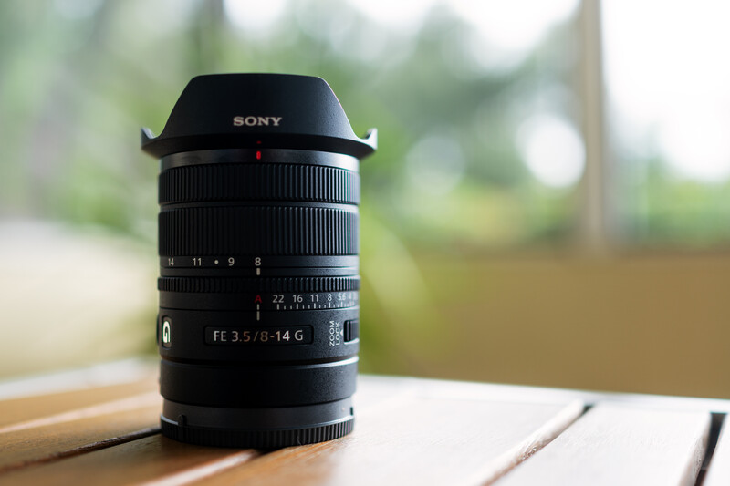 Sony FE 3.5/8-14 G ultra-wide zoom lens with lens hood on wooden surface