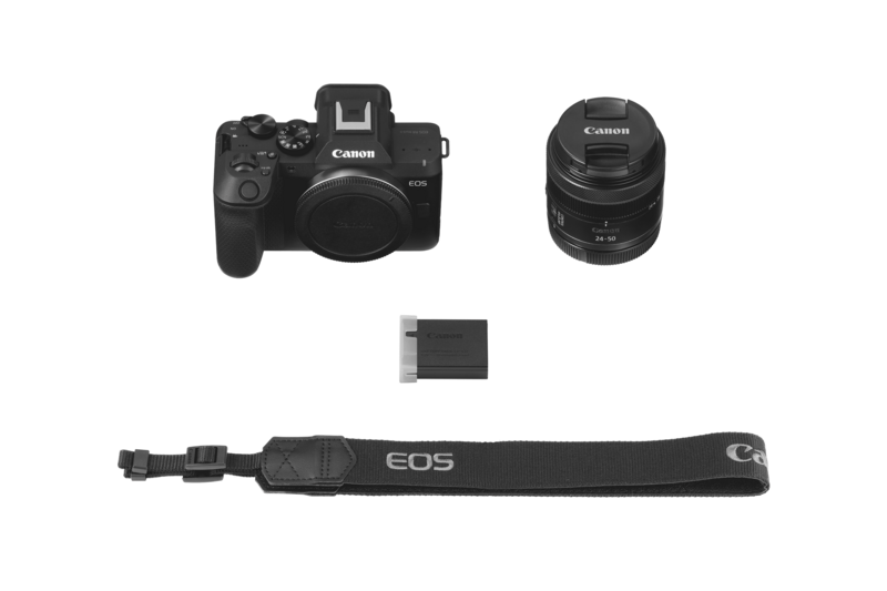 Canon EOS R mirrorless camera body with lens, battery, and shoulder strap laid out flat