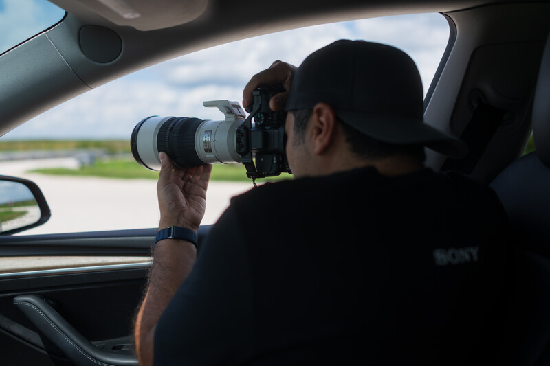 Photographer shooting from inside a moving vehicle with telephoto lens