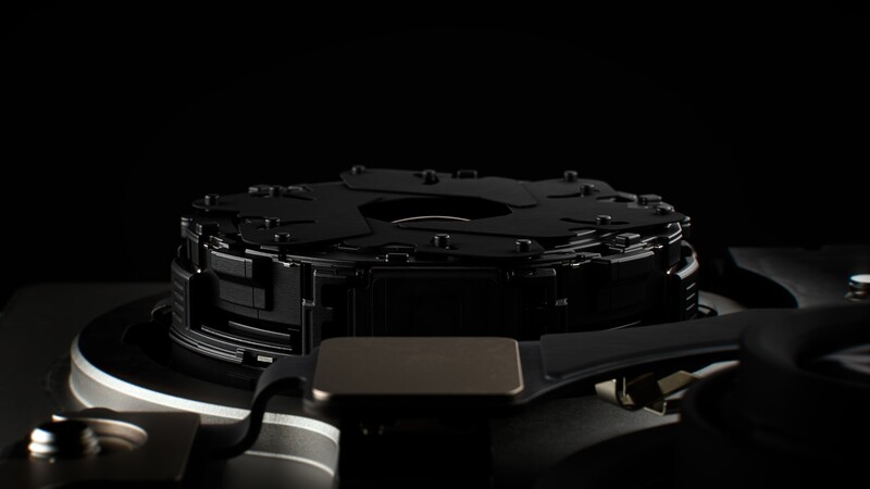Render of a multi-blade iris mechanism assembled inside a lens barrel, shown during the Apple keynote