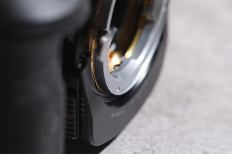 Close-up of a camera lens with golden internal reflections and metallic trim