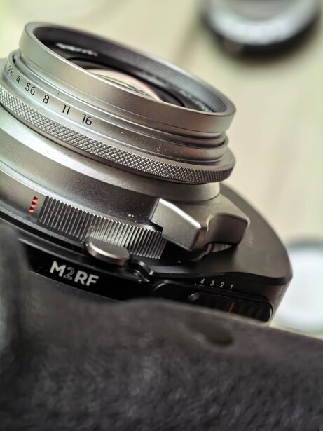 Vintage rangefinder camera lens stack with manual focus and aperture rings