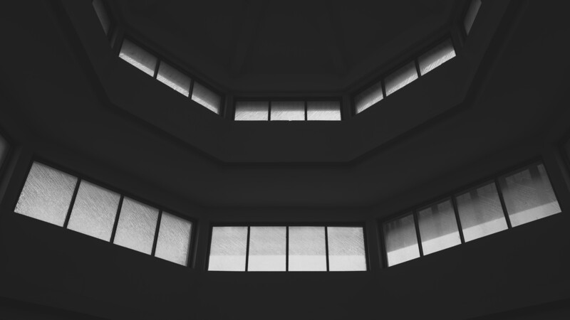 Symmetrical black and white view of stacked curved ceiling levels with rectangular windows