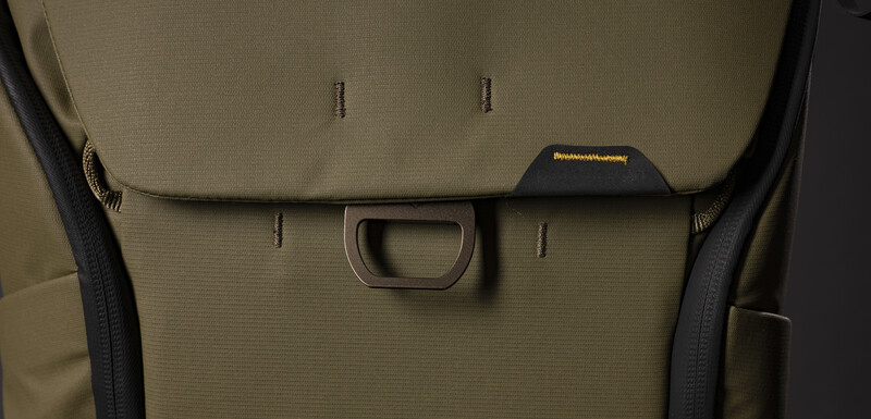 Close-up of tan camera bag exterior showing handle loop and stitching details