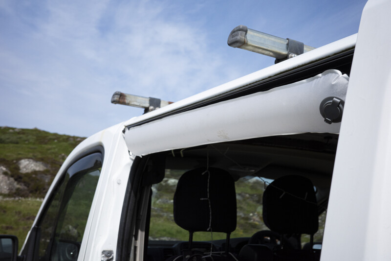 White van roof with dual LED light bars and mounted camera against hillside landscape
