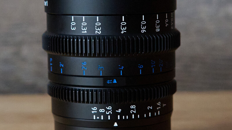 Close-up of cinema lens focus and aperture rings showing depth of field markings