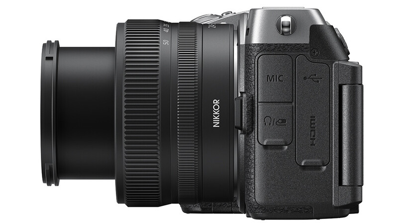 Nikon mirrorless camera with attached zoom lens, side profile view