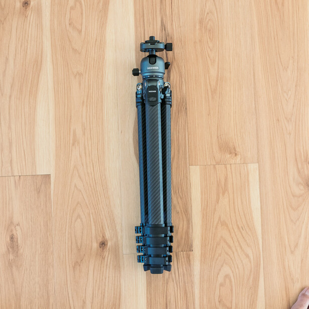 Neewer LiteTrip LT38 carbon fiber travel tripod folded up and ready for travel.