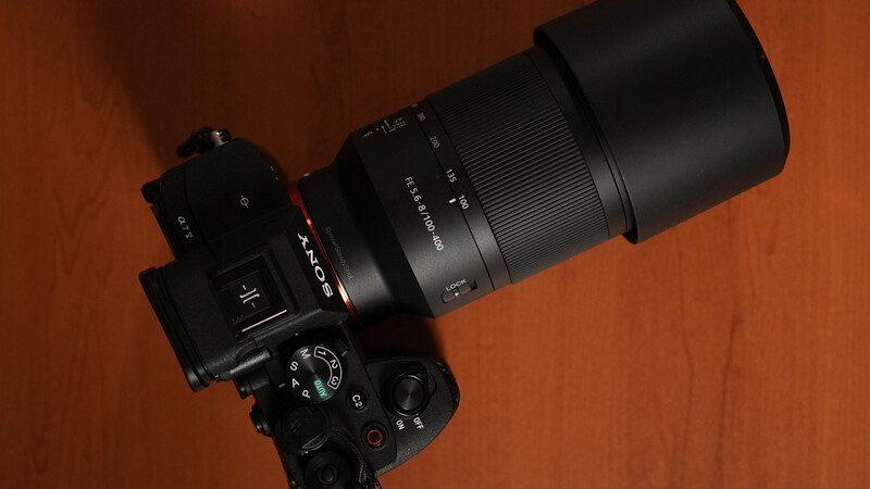 Sony mirrorless camera with telephoto lens mounted on wooden surface