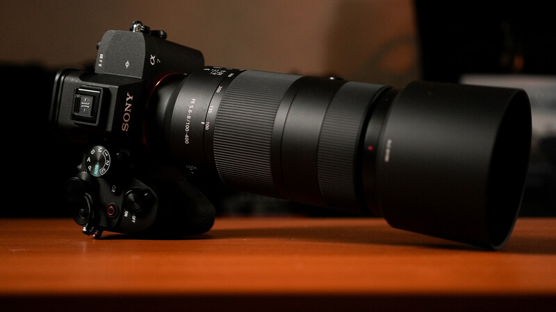 Sony mirrorless camera with telephoto lens on wooden surface