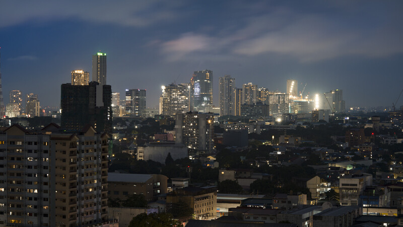 Chicago skyline at dusk with illuminated skyscrapers rising above residential buildings