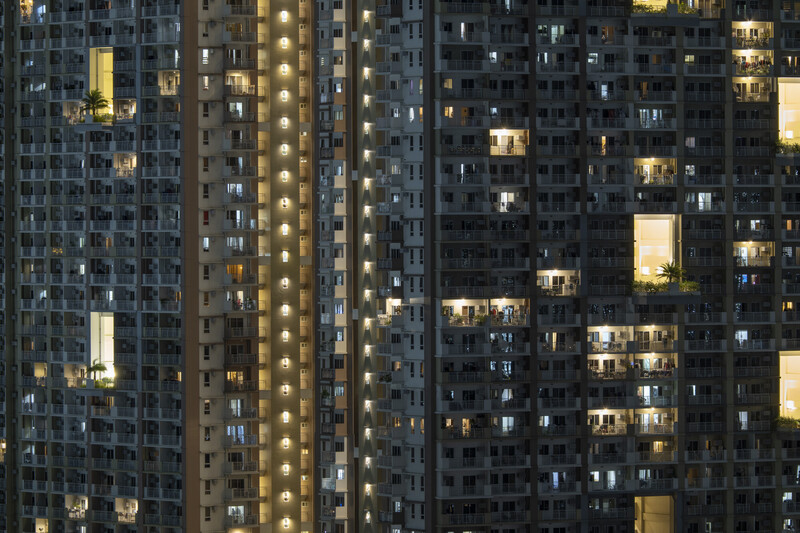 Nighttime cityscape of illuminated residential high-rise apartment buildings