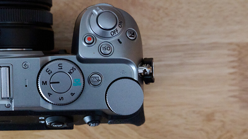 Top-down view of mirrorless camera body with manual exposure mode dial and ISO button visible
