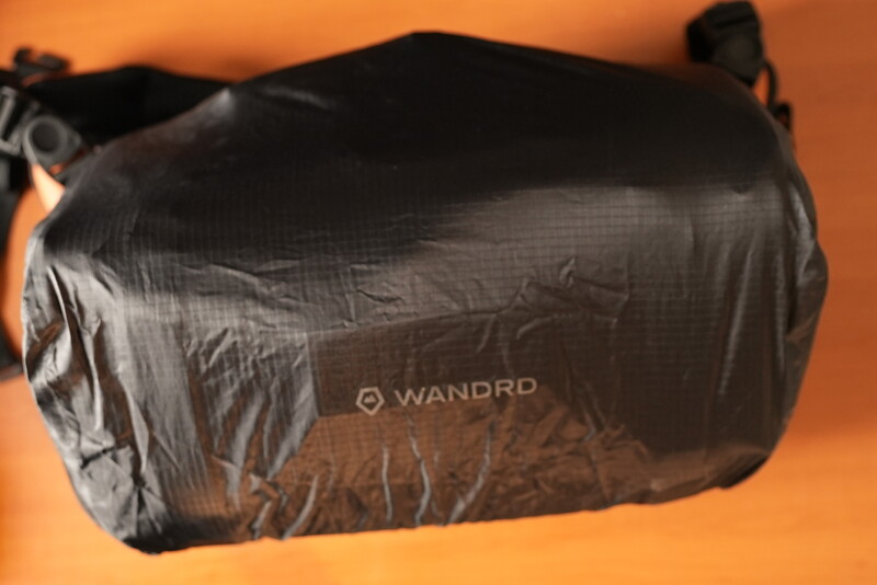 WANDRD black compression stuff sack against warm orange background