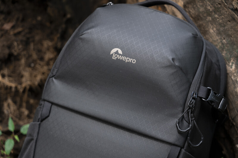 Lowepro camera backpack in dark gray with visible logo and side attachment straps