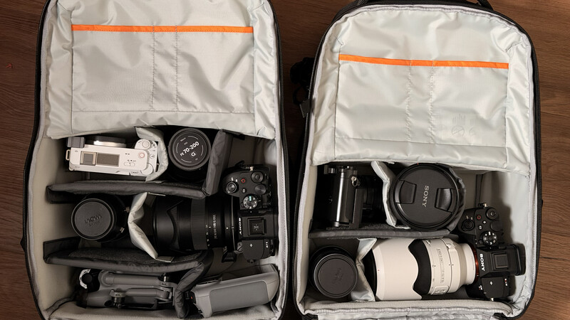Two open camera gear bags displaying organized photography equipment including cameras, lenses, and accessories