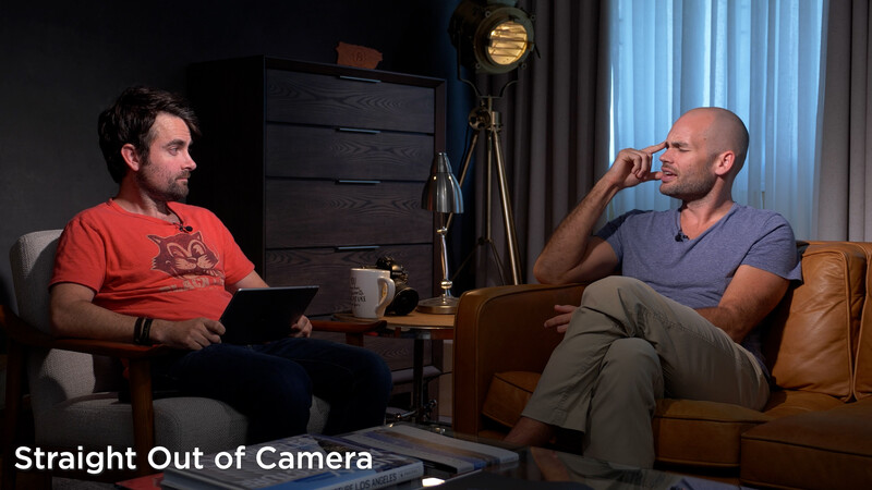 Two men sitting on leather couches in a studio setting during an interview or podcast recording